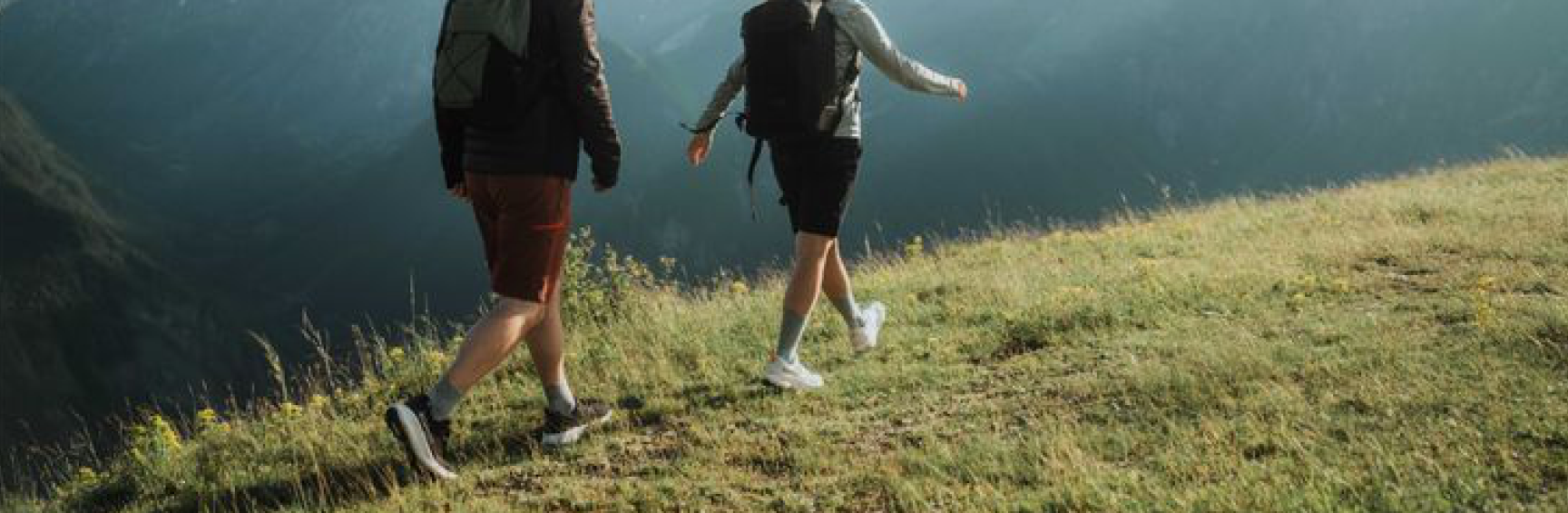 Two people walking a mountain ridge