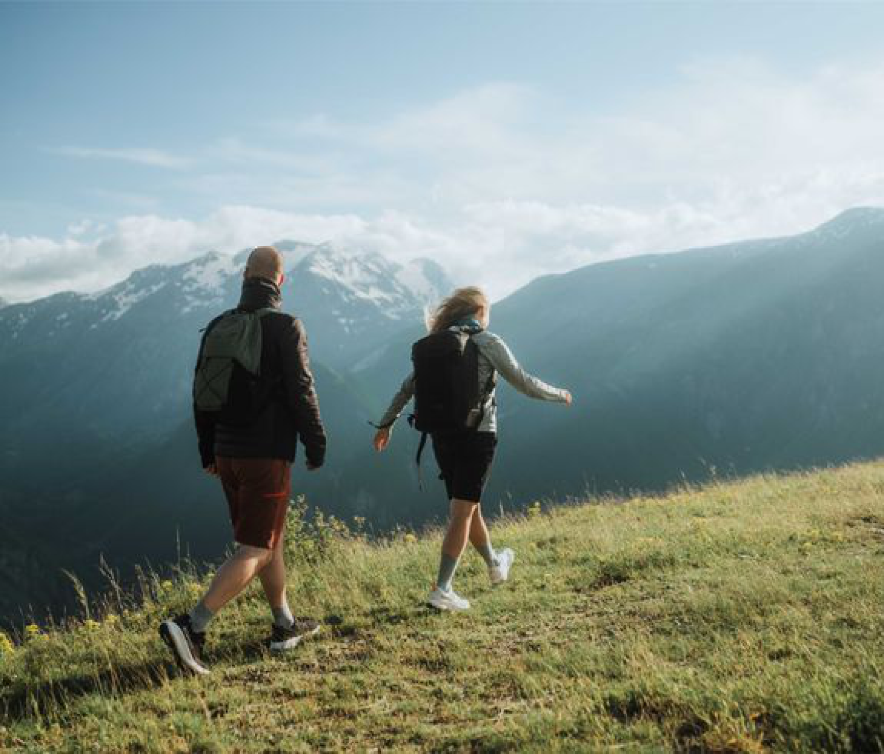 Two people walking a mountain ridge